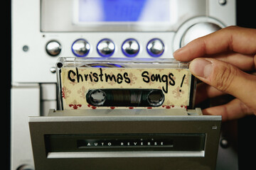 Close up from hand and cassette tapes with Christmas songs - obrazy, fototapety, plakaty