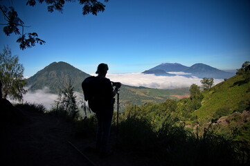 Rear view of woman taking photo on the way to Ijen volcano, Indonesia