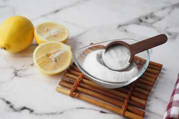 Baking soda and whole lemon on table 