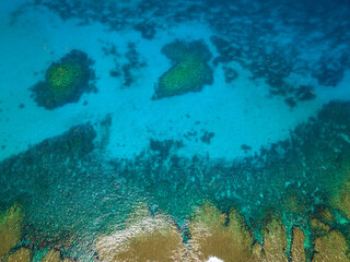 Sea water surface in lagoon with coral reef copy space for text. Aerial view transparent turquoise ocean water surface. Mindanao, Philippines.