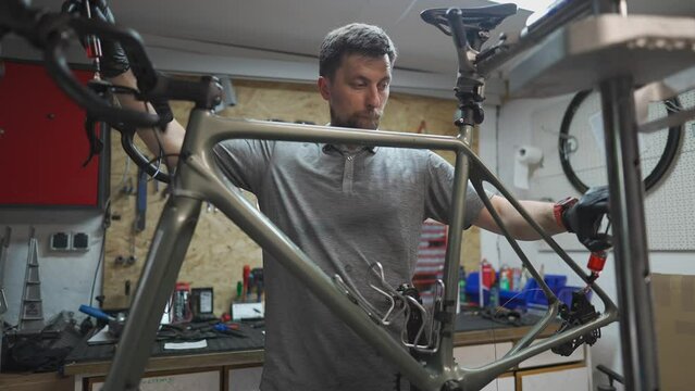 Bicycle mechanic holding syringe with brake fluid during brake bleeding process. Cycle repairman injects brake fluid into hydraulic brakes on bike in workshop. Maintenance cycle brake disc system. 