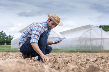 Farmer checking soil conditions in the dry season provides valuable insights into the characteristics of the soil.Smart farming technology and agriculture.