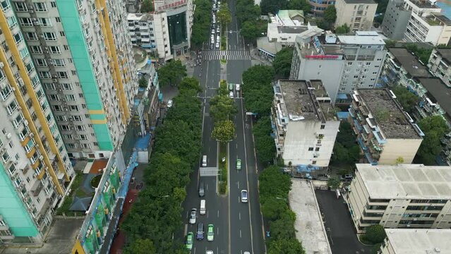 Aerial tracking shot by drone of traffic on busy road sournedned by high raise building in china chengdhu