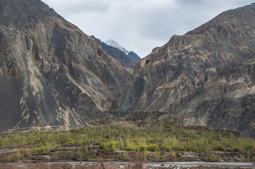 Scenic view of Himalayas and Ladakh ranges. Beautiful barren hills in Ladakh with dramatic clouds in the background.  Road side view, Shyok river , rocks and greenery in base of the mountains.