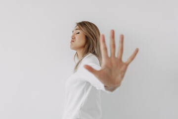 Asian Thai woman grumpy face, open hand showing stop sign gesture, prohibit action, giving negative...