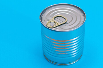 Unopened Tin Can with Blank Edge on Light Blue Background. Canned Food. Aluminum Can for Safe and Long Term Storage of Food. Steel Sealed Food Storage Container