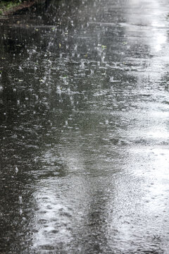 flooded sidewalk during heavy rain with raindrops splashes on water surface