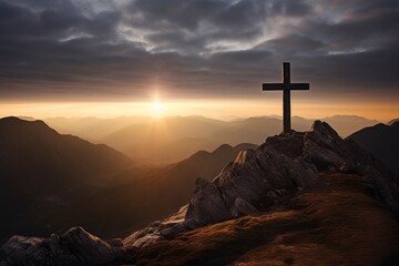 A cross standing on top of the mountain at Sunrise, religious concept background.

