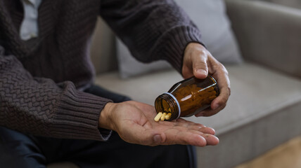 Close-up shot of medicine and hand of elderly person with pills in palm Caring for the health of the elderly with medicine to treat joint pain and arthritis in retirement