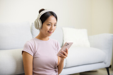 Woman wear headphone and use of mobile phone