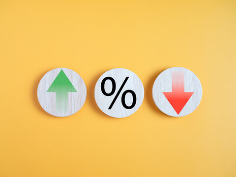 Interest rate financial and mortgage rates concept. Circle wood with icon percentage symbol and arrow up and down direction on yellow background.
