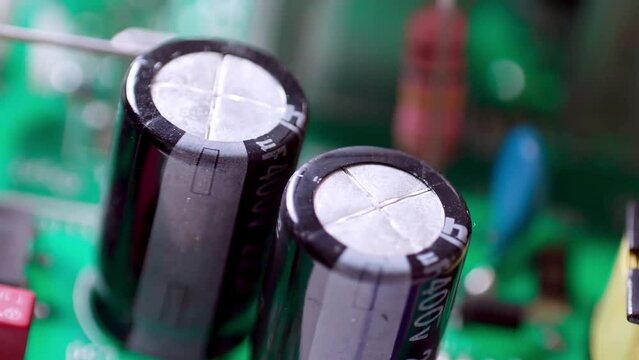 Zooming out of the capacitors on a circuit board of an electronic gadget.