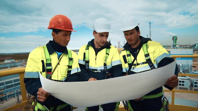 Team of industrial male builder discuss plant factory engineering development use plan blueprint
