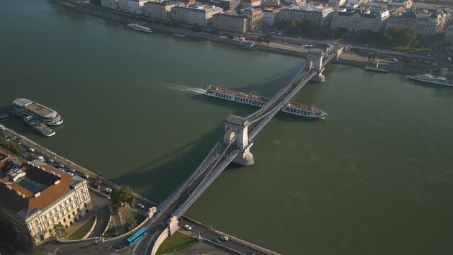 High Aerial View Above Szechenyi Chain Bridge in Budapest, Hungary. Pan Up Reveals City