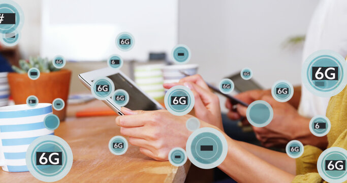 Image of 6g texts with symbols over caucasian coworkers using digital tablet