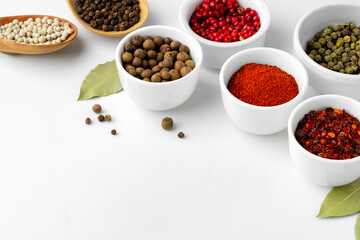 Various spices in a bowls on white background