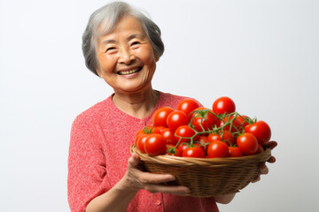 Fototapeta na wymiar Elderly Asian woman with a basket of tomatoes