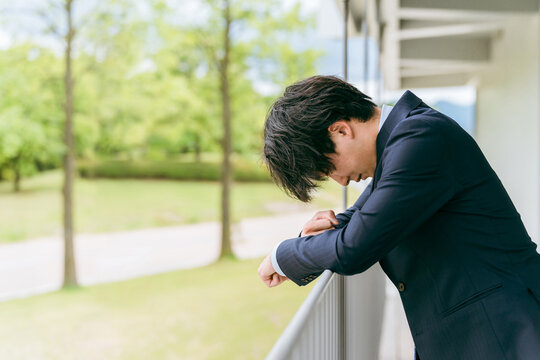 ストレス・ミス・悩む・トラブル・困る・疲労・落ち込む若いアジア人ビジネスマン
