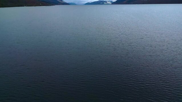 flying across  Loch Ness Lake revealing the picturesque  hills on the horizon
