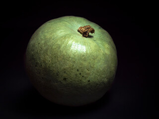 Close-up of a light-green squash on a dark background