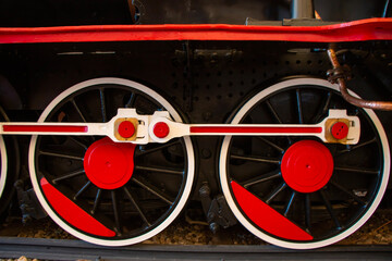 Old style red and white colored steam locomotive wheel.