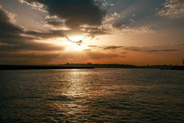 Obraz premium Calm view of the sunset gliding through the clouds over the calm sea