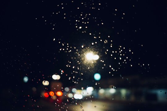 Bokeh , Rain Drops Falling down on background view, High quality photo of Rain on Window Sky Drops, Close up Slow Rain, Rainy day, Heavy Rainfall. Raining in car mirrors on traffic.