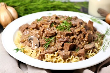 white plate with beef stroganoff and a garnished white napkin