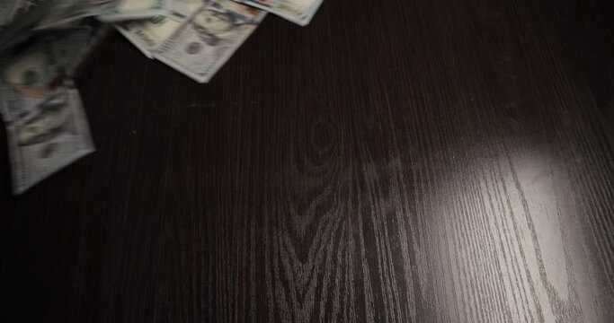 Bunch of dollar banknotes blows off table. Paper money blown away table by wind. Concept of wasting money, departing wealth, declining profits, wages, falling business, destroying commercial scheme.