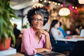portrait of an elegant middle age black  woman with laptop posing on camera in a coworking space indoor  