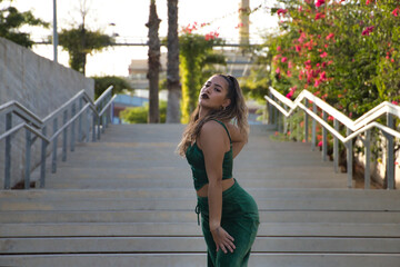 Obraz premium Latin and Hispanic girl, young and beautiful, dancing modern dance in the street outdoors. Dance concept, moonwalk, jumpstyle, shuffle, electrodance, hip hop, funky, popping.