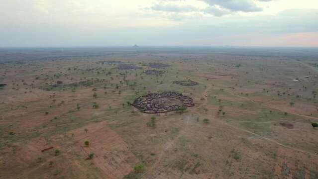 Traditional tribal village of Ugandan tribesmen in African savannah of Karamoja region. Uganda in Africa. Aerial circling