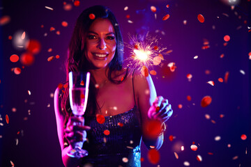 Portrait of a beautiful, glamorous-looking woman, celebrating New Year’s Eve, drinking alcohol...