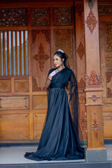 Naklejka premium Women's fashion model. Female makeup model. Asian woman. Indonesian women. wearing a black wedding dress. Black wedding dress.