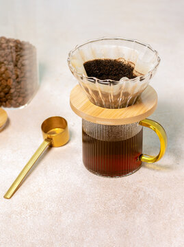 Making coffee with paper filter and pour over in glass cup.