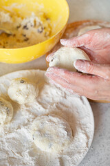 Caucasian female hands making cottage cheese pancakes with raisins cooking background