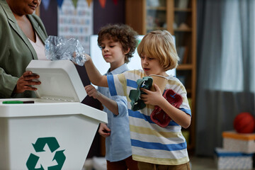 Portrait of children sorting plastic and paper in recycling class at preschool, copy space - obrazy, fototapety, plakaty