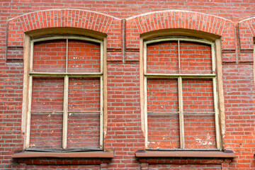 Old red wall and windows blocked with red bricks