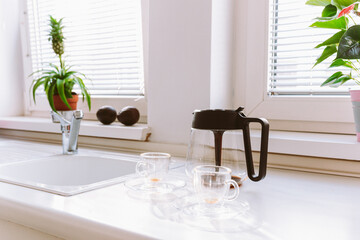 empty glass coffee cups and coffee pot on tabletop