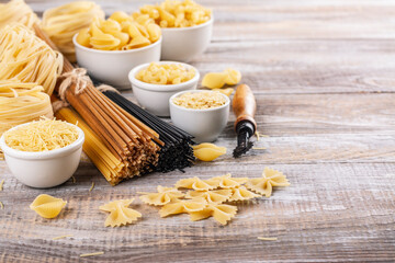 Pasta month. Assortment of uncooked pasta and noodles. Italian food culinary concept. Collection of different raw pasta on cooking table