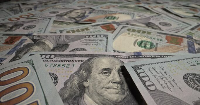 One hundred dollars in large quantities lie on table close up. Scattered money lies in background all over surface. Huge stack of one hundred dollar bills, illustration of luxury and financial success