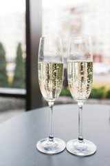Close-up of two filled glasses of champagne on a table indoors, party wedding concept.