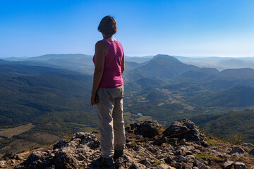 Fototapeta premium Randonneuse au sommet du Pech de Bugarach contemplant le Fenouillèdes et le Roussillon 