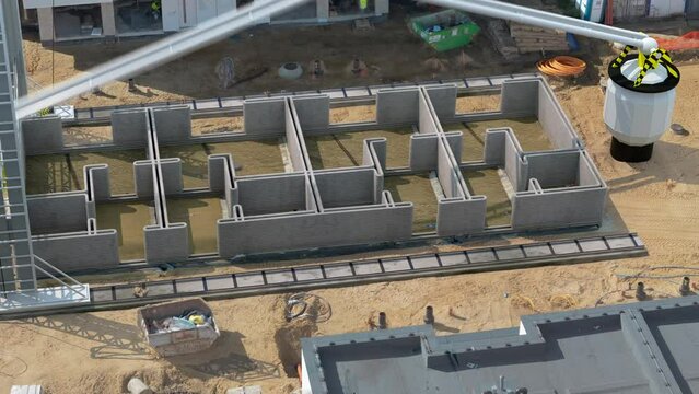 Time-lapse video of a grand house printer laying concrete strata, progressively constructing a home on site.