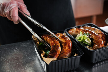 chef cooks delicious fried sausages in the kitchen in the restaurant