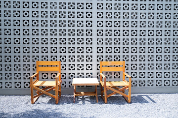 Wooden chairs with backrests are paired with small wooden tables in the rock garden for relaxing