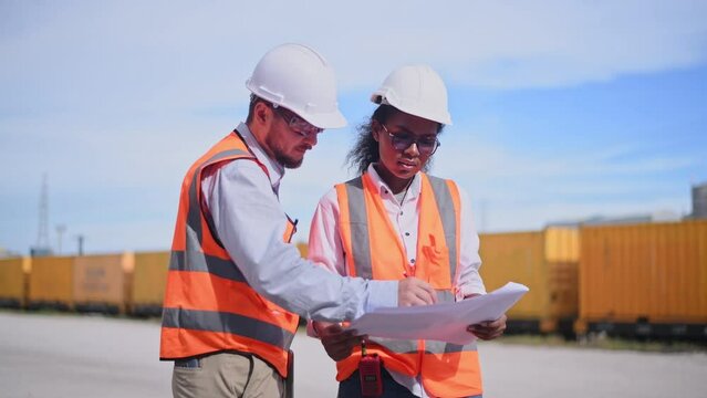 Engineers railway team wearing safety uniform under conversation document on hand inspection survey container boxes railway work station is industry transportation cargo import export concept.