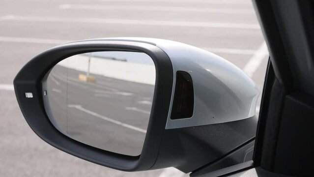 System blind spots of the car. Detail of side keeping assist system switch button. Blind zone monitoring sensor on the side mirror of a modern electric car
