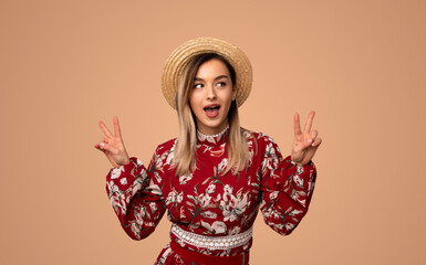 Happy woman in summer outfit showing peace signs
