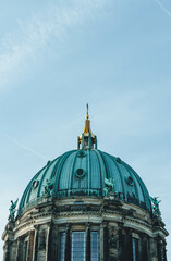 view of huge dome of catholic church with massive gold cross on top 